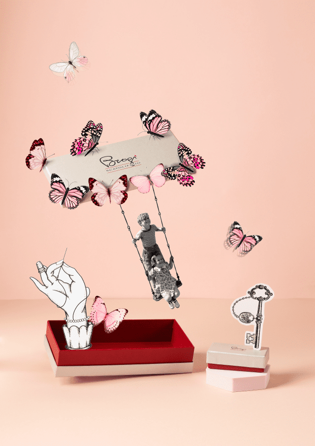 un gruppo di farfalle rosa alza il coperchio della scatola che sorregge un altalena su cui stanno giocando due bambini
